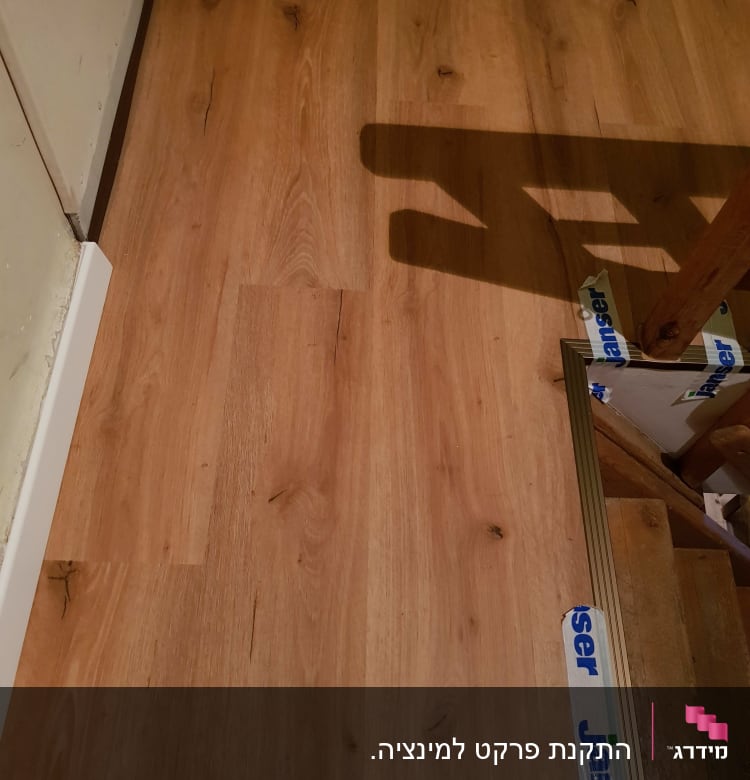 רצפת פרקט עץ עם גימור בהיר ופסי חיבור